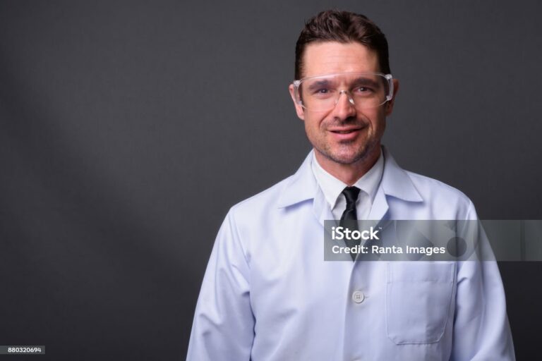 Portrait Of Man Doctor Against Gray Background